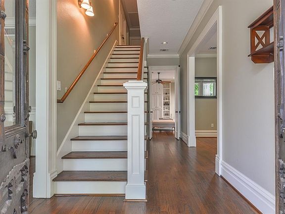 As you walk in the entry, notice the hardwood floors and custom molding detail throughout home.  The "old world" front doors were crafted from the 1800's in Louisiana.