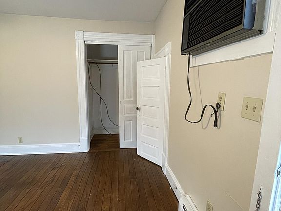 Living room with hardwood floors and semi-permanent wall air conditioner.