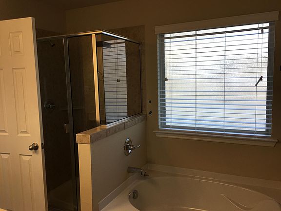 Garden tub and glass shower stall in primary bathroom