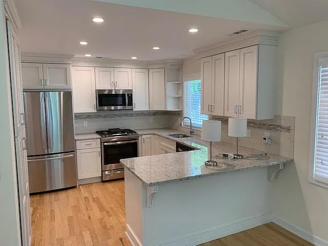 kitchen has upgraded appliances and cabinetry and large pantry on left
