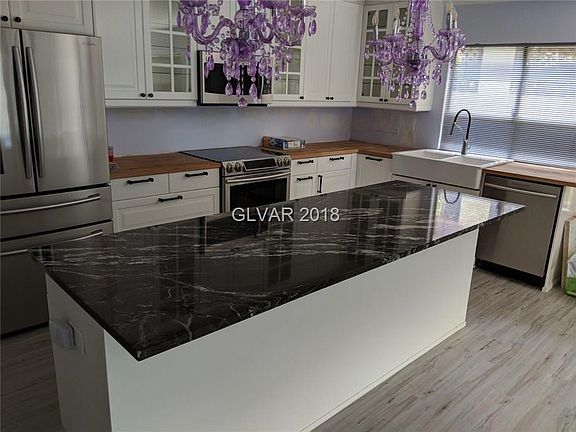 Remodeled kitchen with granite and butcher block countertops, newer stainless appliances, and custom cabinets.