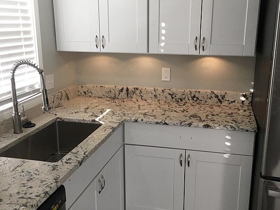 Dishwasher and edge of large fridge, and beautiful plank flooring