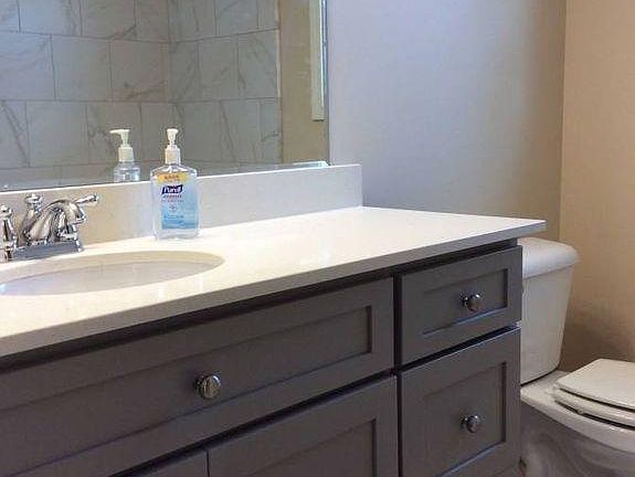 Bath w/ tile floor and full tub shower surround.