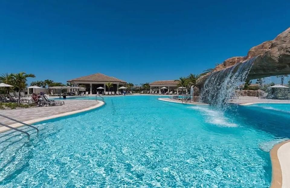 Lagoon style pool with cascading waterfalls, includes swim lanes, hot tub, and poolside tiki-bar.