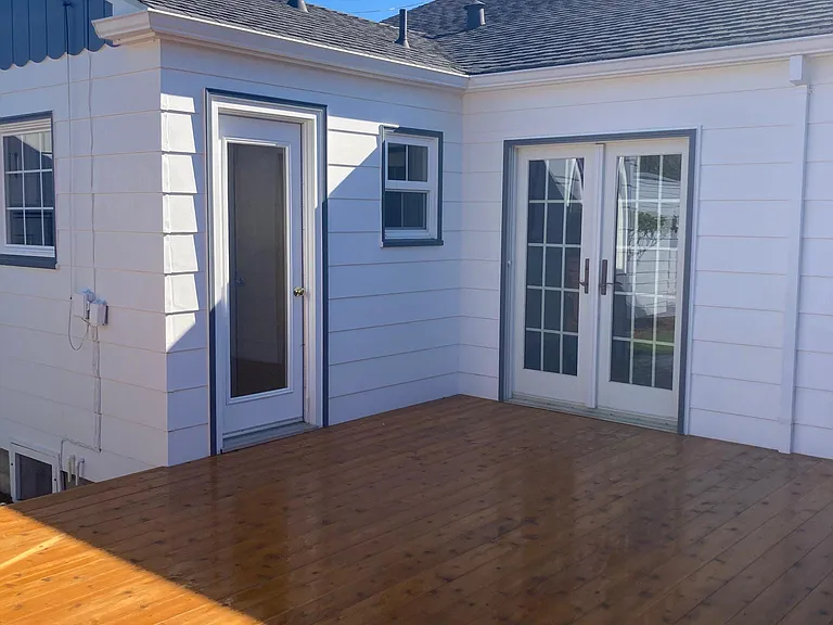 Deck with French doors opening to bedroom and single door opening to laundry and half bath