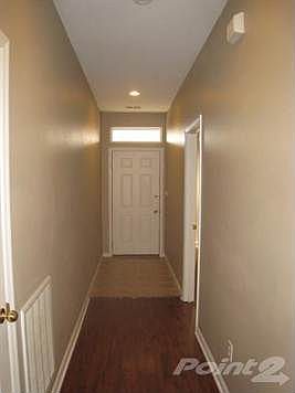 Foyer area with tile floors and laminate wood flooring in the hallway.
