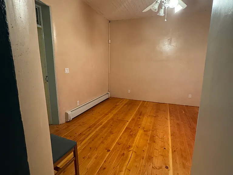 Master bedroom with hard wood floors & ceiling fan