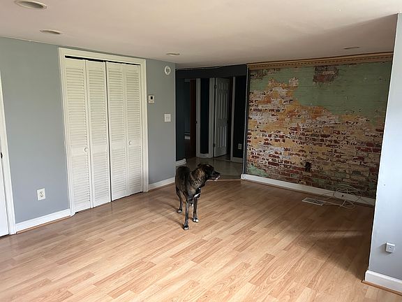 Living room with windows behind look toward foyer.