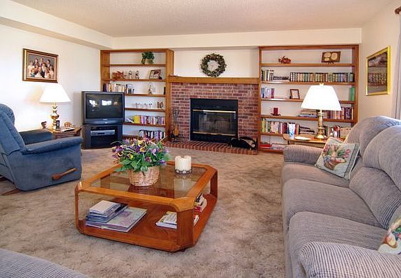 Spacious family room with wood burning fireplace and built in shelves! 