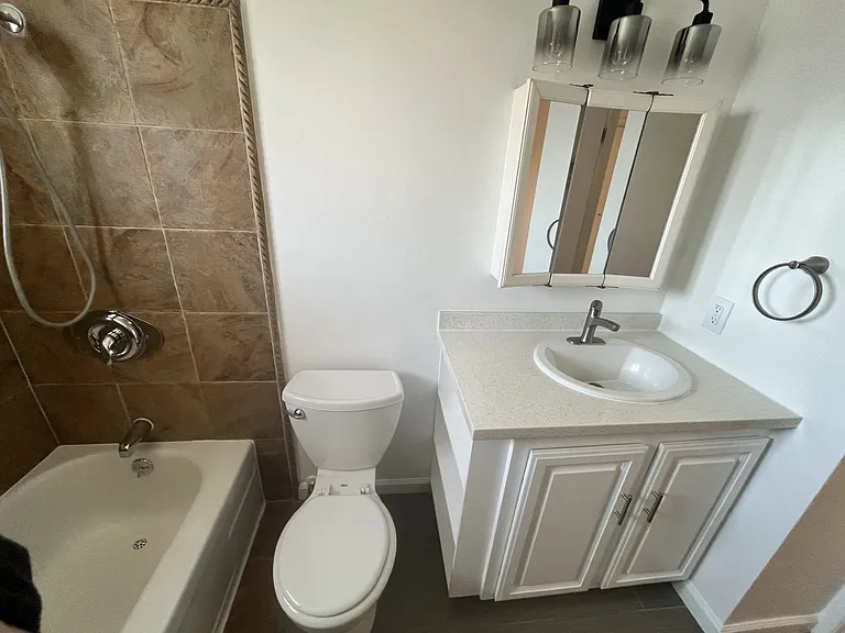 2nd floor tub/shower bath, stone look tub surround, quartz counter top, storage in mirrored medicine cabinet, updated light and plumbing fixtures. Nice floor tile.