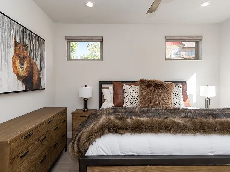 Inviting guest bedroom with cozy mountain-inspired decor, warm textures, and abundant natural light for a restful retreat.