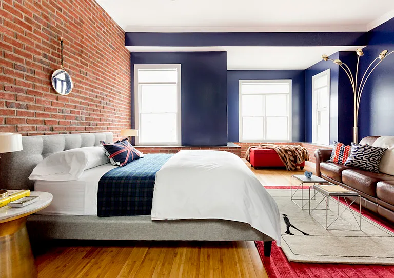 Master suite with queen bed and leather sofa, walk-in closet, exposed brick wall, 4 windows and skylights!