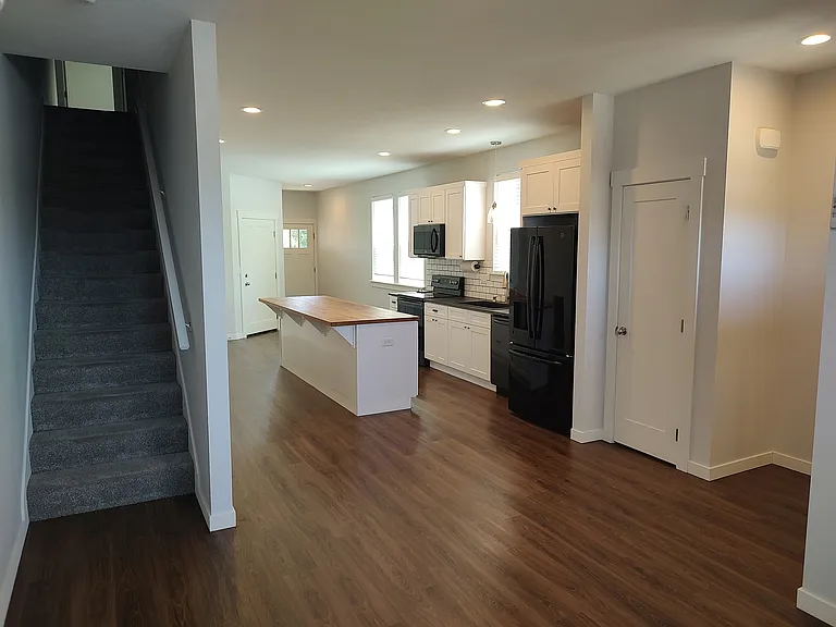 Living room facing kitchen with stairs
