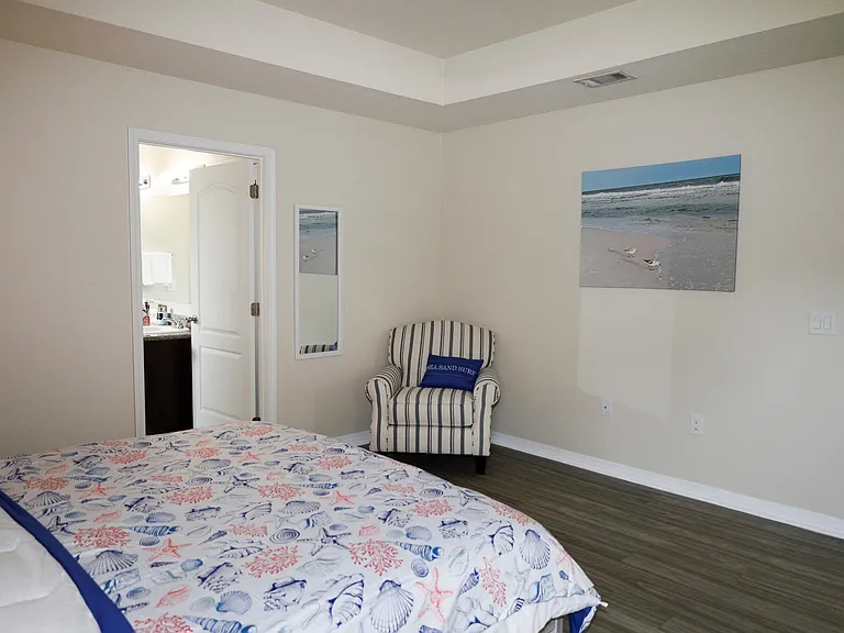 The second bedroom offers a comfortable king-size bed and a perfect workspace with a serene backyard view_ideal for work and relaxation.
