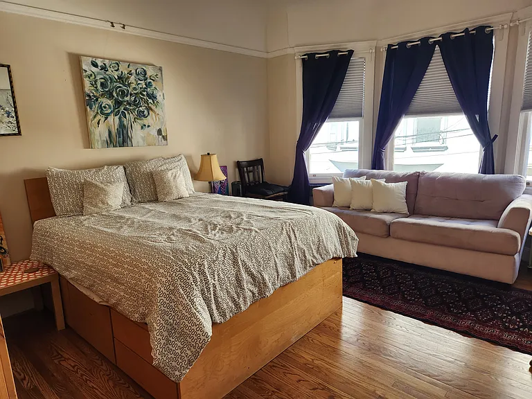 Large master bedroom with armoire and sofa