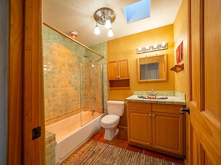 Second bathroom with skylight and window. Saltillo tiles throughout house.