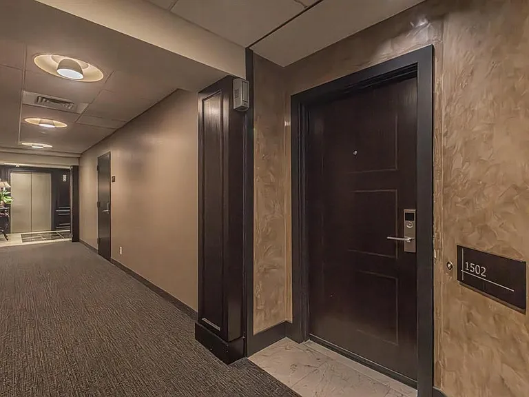 Apartment entry door 1502 featuring a dark wood-finish, modern handle, and secure lock system