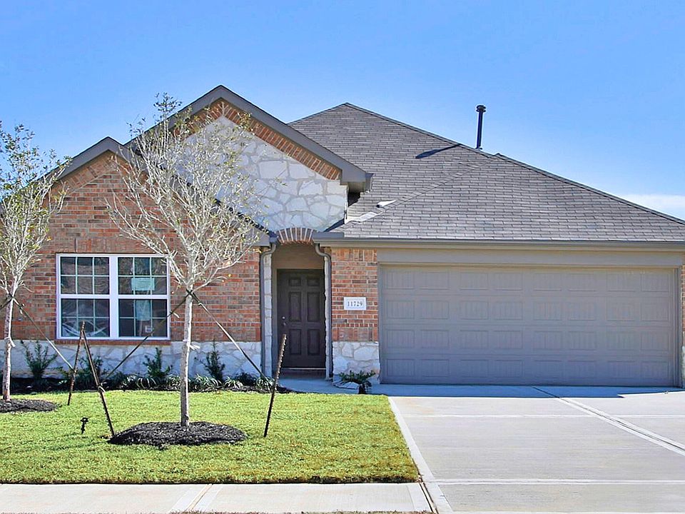 Elegant brick facade with stone accents and dual garage in Cielo. Luxurious living in a modern desig