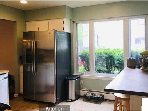 Kitchen with breakfast nook with large window facing the backyard. All stainless steel appliances.