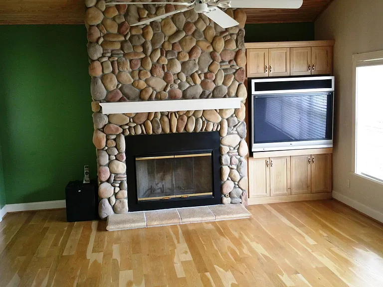 This is the family room with big screen TV and surround sound. Note: the green wall on the left has been painted in the same linen white as the rest of the room. The window looks out on the lake.