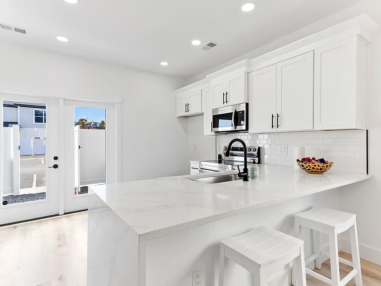 The kitchen is complete with a refrigerator, an electric stove with oven, a microwave, a dishwasher, and a disposal.