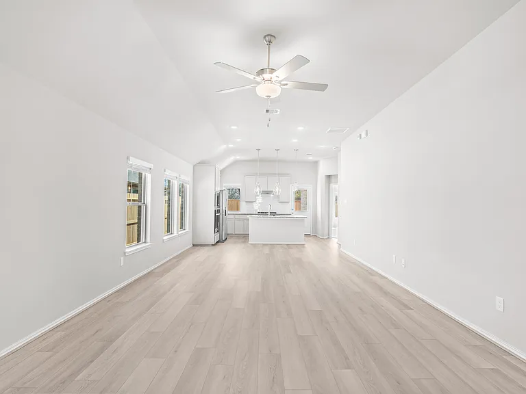 Spacious family room with vaulted ceiling, recessed lighting, ceiling fan, and open sightlines to the gourmet kitchen a?? ideal for everyday living and entertaining.