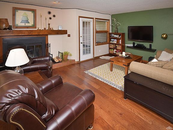 Living room with woodburning fireplace and access to large deck