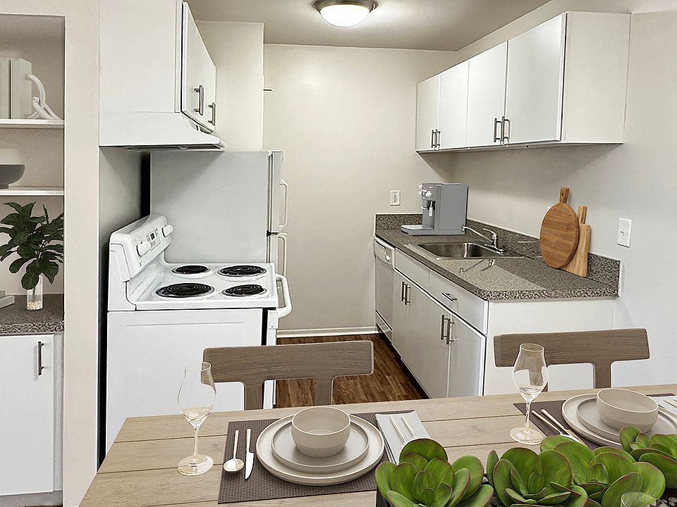 Kitchen/dining/pantry area with white appliances and wood plank flooring..