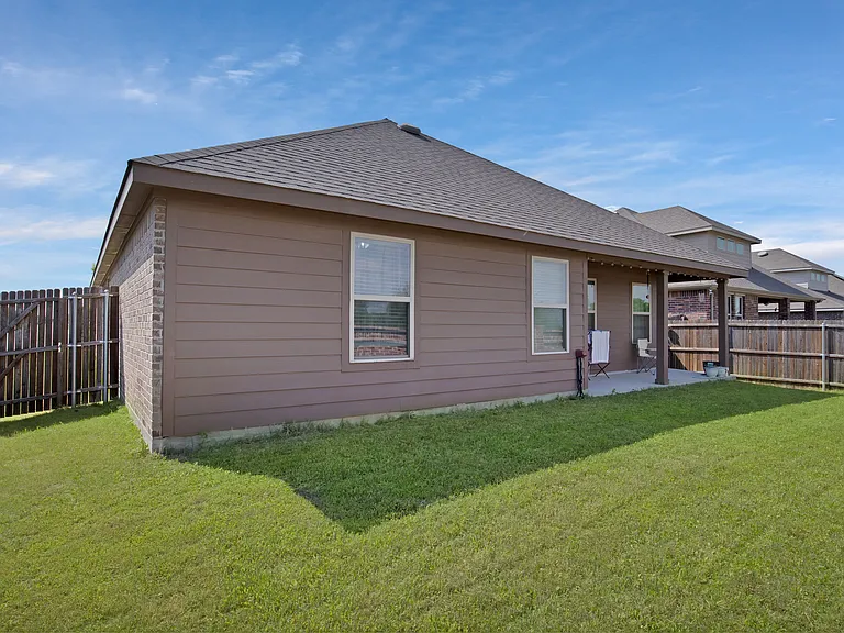 Rear view of house with a patio area, a lawn and a fenced backyard