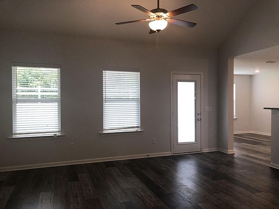 Great room with high ceiling and natural lighting, ceiling fan with light, laminate flooring on 1st