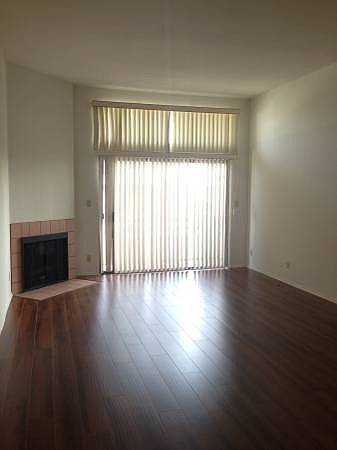 Charming living room with fireplace, wood floors, and bright