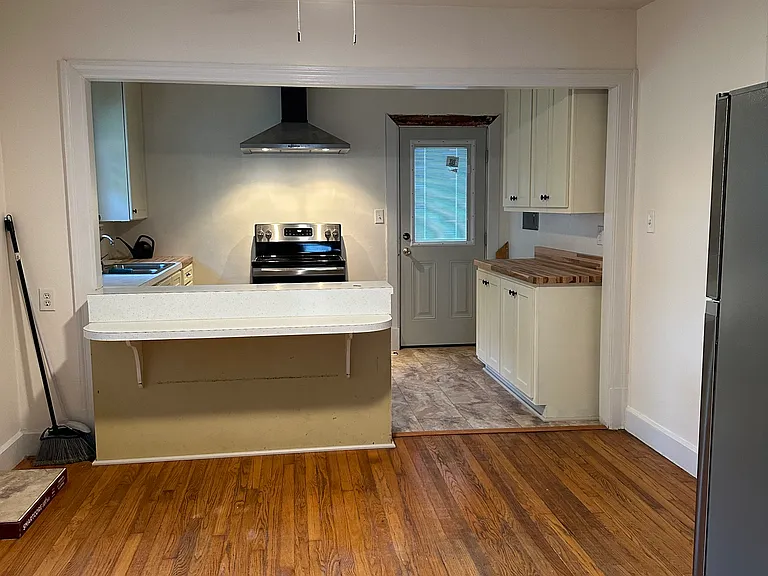 Kitchen dining area looking into work area. Dining area has new ceiling fan and great hardwood floors.
