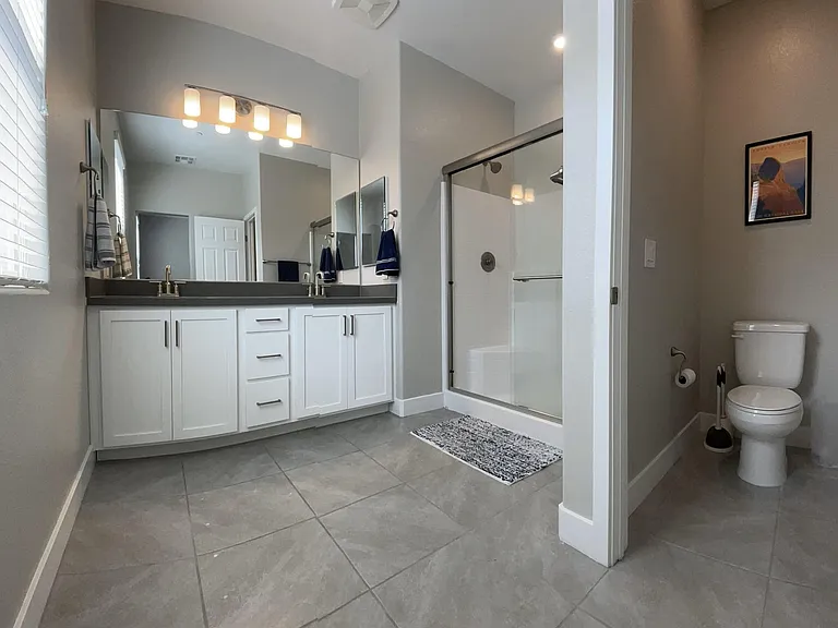 Second floor primary en suite bathroom with dual sinks, shower, and water closet for added privacy.