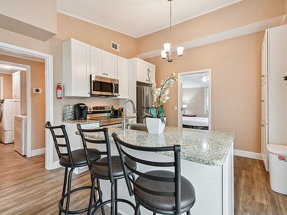updated kitchen with granite counter tops, custom cabinets, and stainless steel appliances