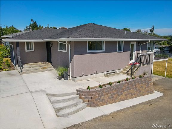 Fresh exterior paint. New poured concrete driveway, stairs, and retaining wall in front of the home.