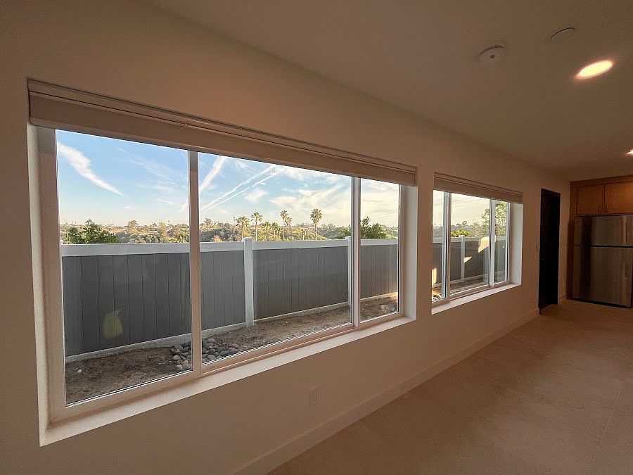 Windows with top-down bottom-up black-out blinds overlook private fenced yard