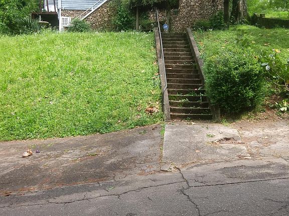 A house on a hill! Front yard swing with a vine canopy.