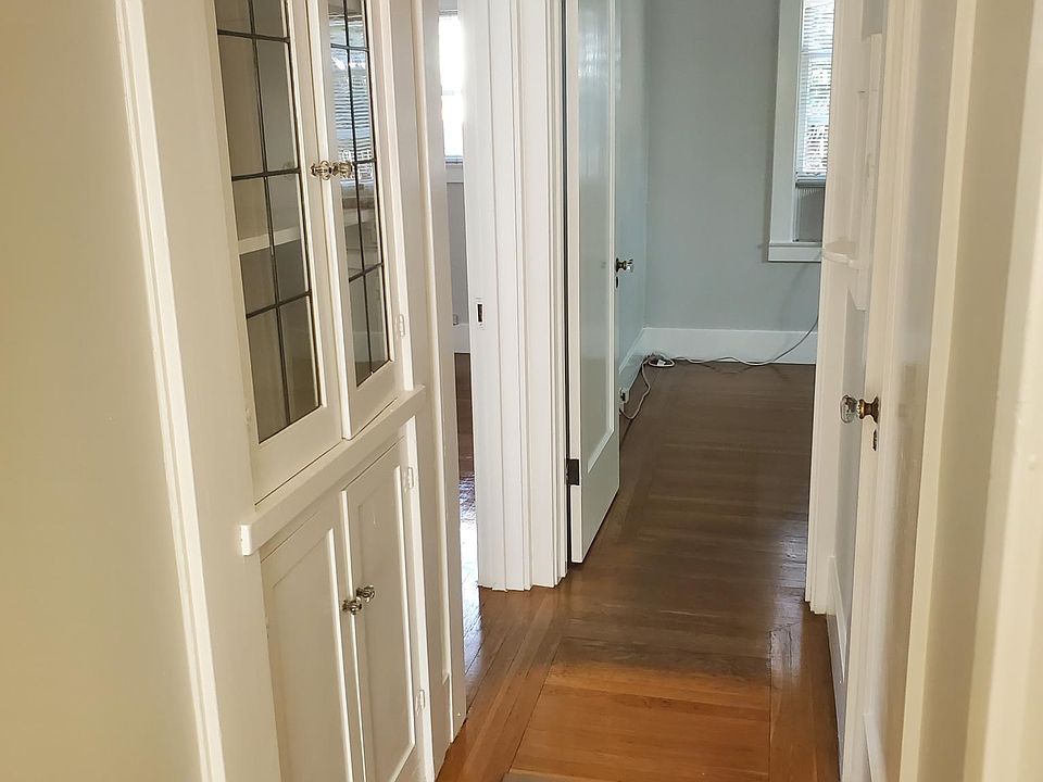 Hallway with built-in cabinets and walk in closet