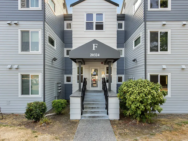 Building entrance with one uncovered parking space in front