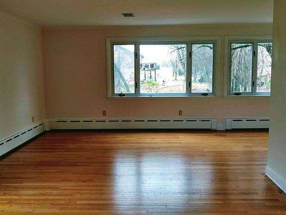 View of the Living Room, standing next to the fireplace. Dining Room is up around the corner to the right.