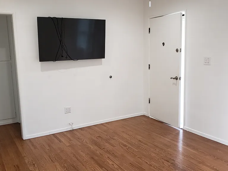 Front room, with front door on the right and entrance to hall on the left.