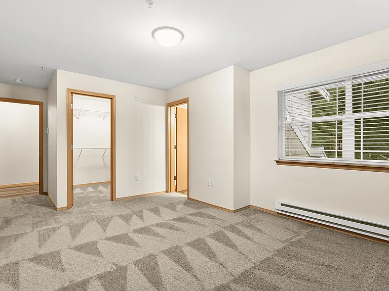 Bright and comfortable bedroom featuring a walk-in closet, large window, and clean, newly refreshed carpeting. Bright and comfortable bedroom featuring a walk-in closet, large window, and clean, newly refreshed carpeting.