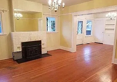 Living room with wood burning fireplace; original fir floors