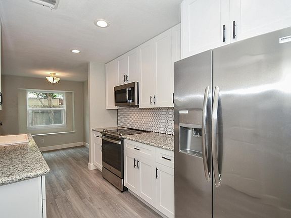 Your kitchen is complete with recent stainless steel appliances and granite countertops. note the raised ceiling in the kitchen.