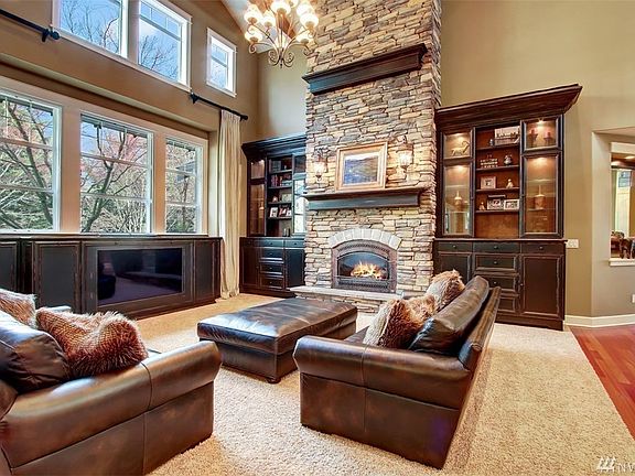 The commanding great room is the heart of the home and boasts soaring timber beamed ceiling with up lighting, floor to ceiling stacked stone gas fireplace with raised hearth and 2 mantles.
