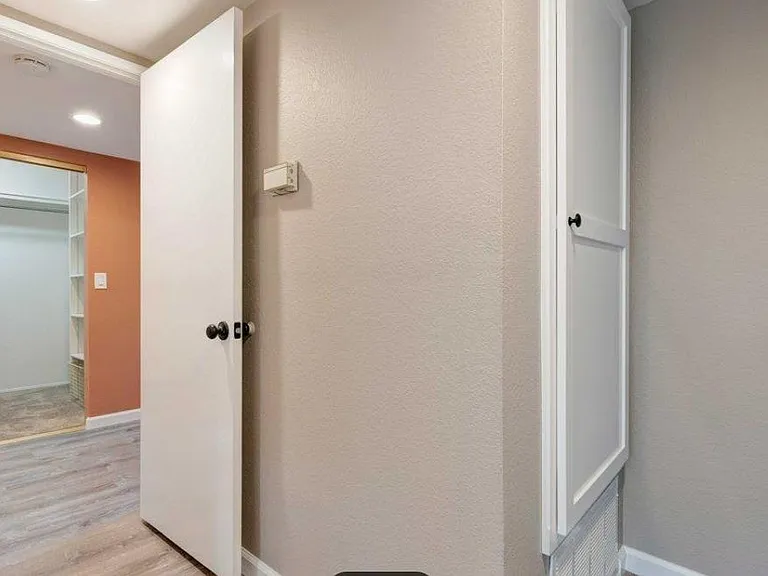 View of master bedroom closet from hallway. Master bedroom paint color updated to neutral color of hall.