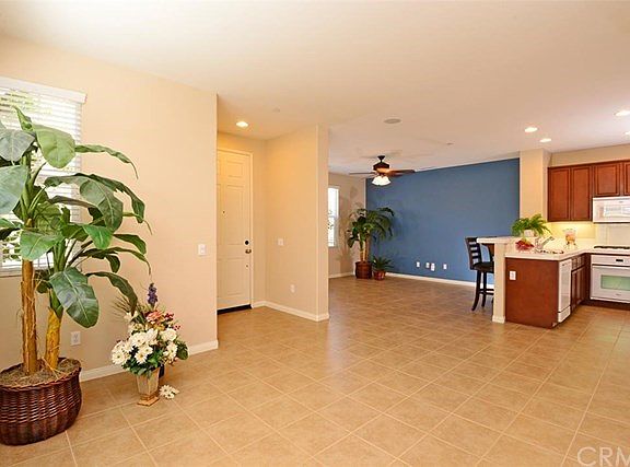 Award-winning architects and designers created the contemporary and functional floor plans found at Bradford Court.  The formal entry is seen here on the left and the living/family room sports the blue accent wall.  Attractive and easy care 12 x 12 tile f