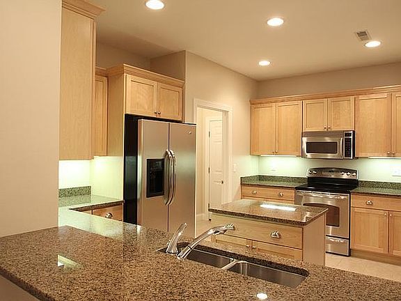 Kitchen with double sinks, granite countertops, island work space.