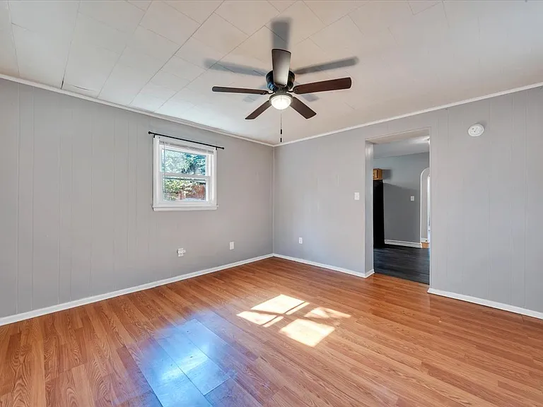 Spacious Den w/ Designer Ceiling Fan and Newly Painted Sherwin Williams Light French Gray Paint! Blinds Provided by Landlord! NEW Black Matte Curtain Rods Installed by Landlord!