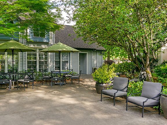 Outdoor sitting area with tables, chairs and umbrellas.